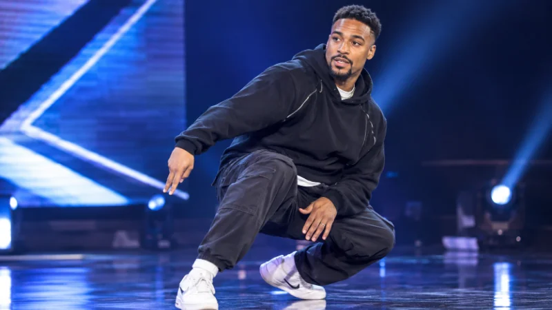 ordan Banjo performing a street dance routine on stage